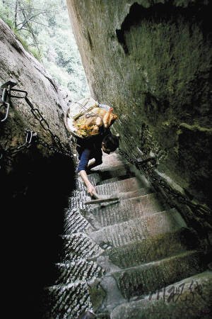 華山第一險道“千尺幢”與地面幾乎呈80度，何天武背著60多斤的菜，一只手還要拿著拐杖，只能艱難爬行。