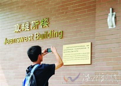 一名清華大學學生在拍攝“真維斯樓”的銘牌5月24日攝。