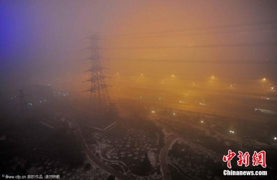 剛告別初雪，京城陷入“霧區”。2011年12月4日晚，北京阜石路石景山區楊莊段，被大霧籠罩。李文明 攝 CFP視覺中國