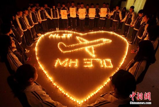 浙江諸暨海亮國際學校師生點燃蠟燭為馬航失聯(lián)飛機上的乘客祈福