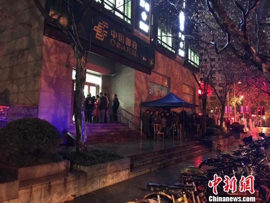 1月5日清晨5點半，在上海靜安郵政支局，市民冒著寒風與冷雨，撐傘排隊，搶購首發的戊戌狗年生肖郵票。　郭容 攝
